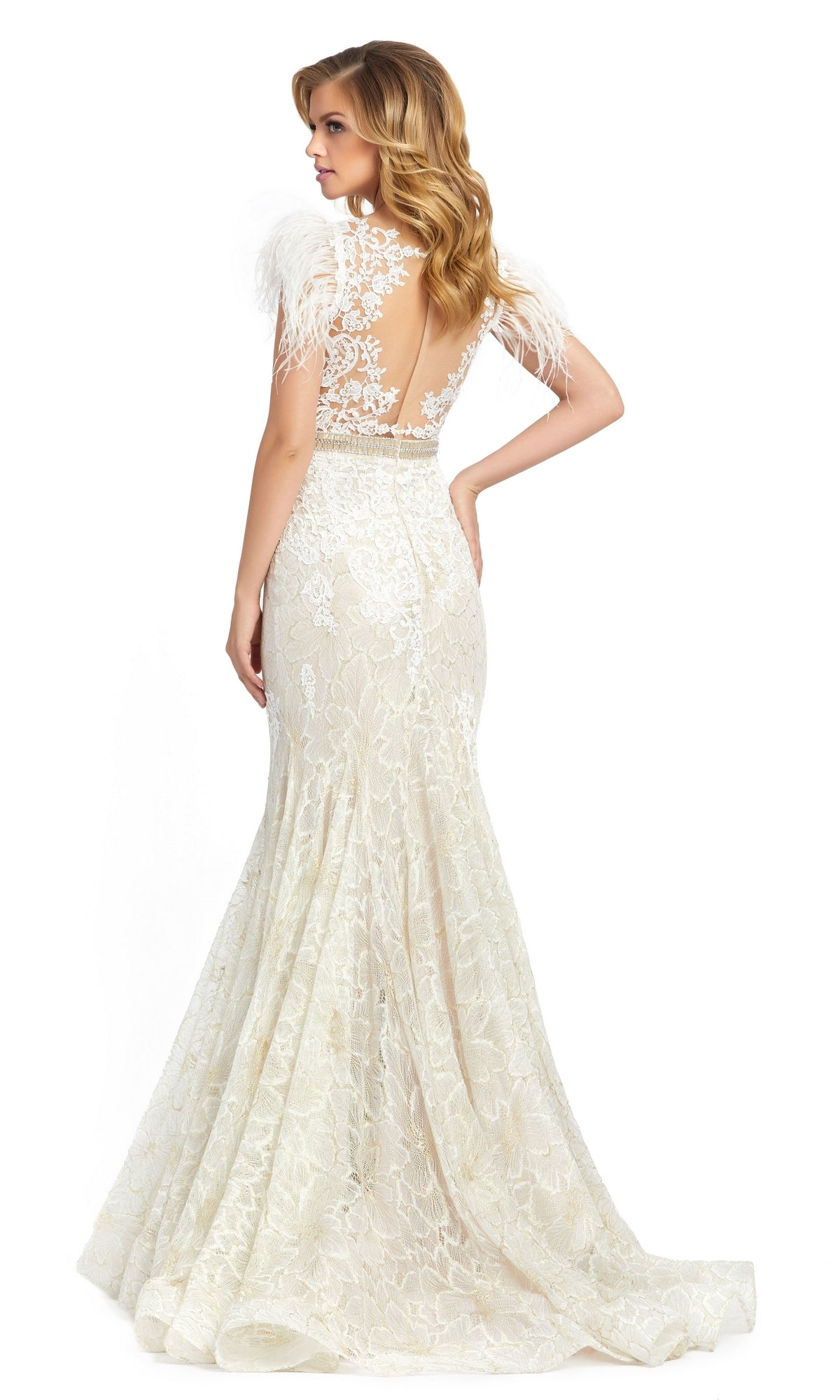 A woman stands facing away in the Mac Duggal 79230 Feathered Long Lace Formal Dress—an elegant, floor-length ivory gown featuring lace details, a sheer back, and feathered shoulder accents.